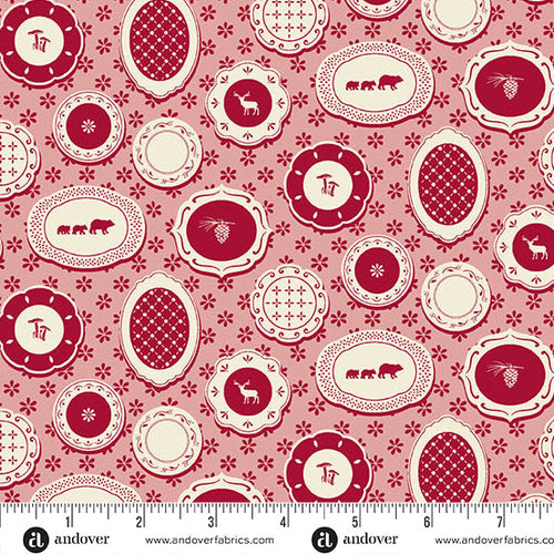 A repeating vintage-style pattern featuring cream-colored decorative medallions and floral motifs on a dusty rose pink background. The medallions contain simple illustrations such as bears, deer, pinecones, and geometric lattice patterns. with ruler and andover branding