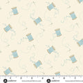 A repeating fabric pattern on a warm cream background featuring light blue spools of thread, small needle, and delicate heart and vine motifs. A white ruler strip with Andover branding and website text appears along the bottom edge.