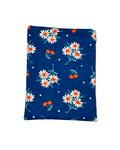 Floral patterned e-reader sleeve with white daisies and red cherries on a blue fabric with a white background