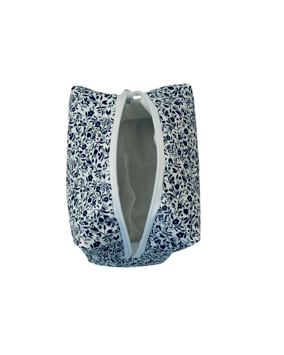 white and navy Floral-patterned toiletry bag with a open white zipper on a white background